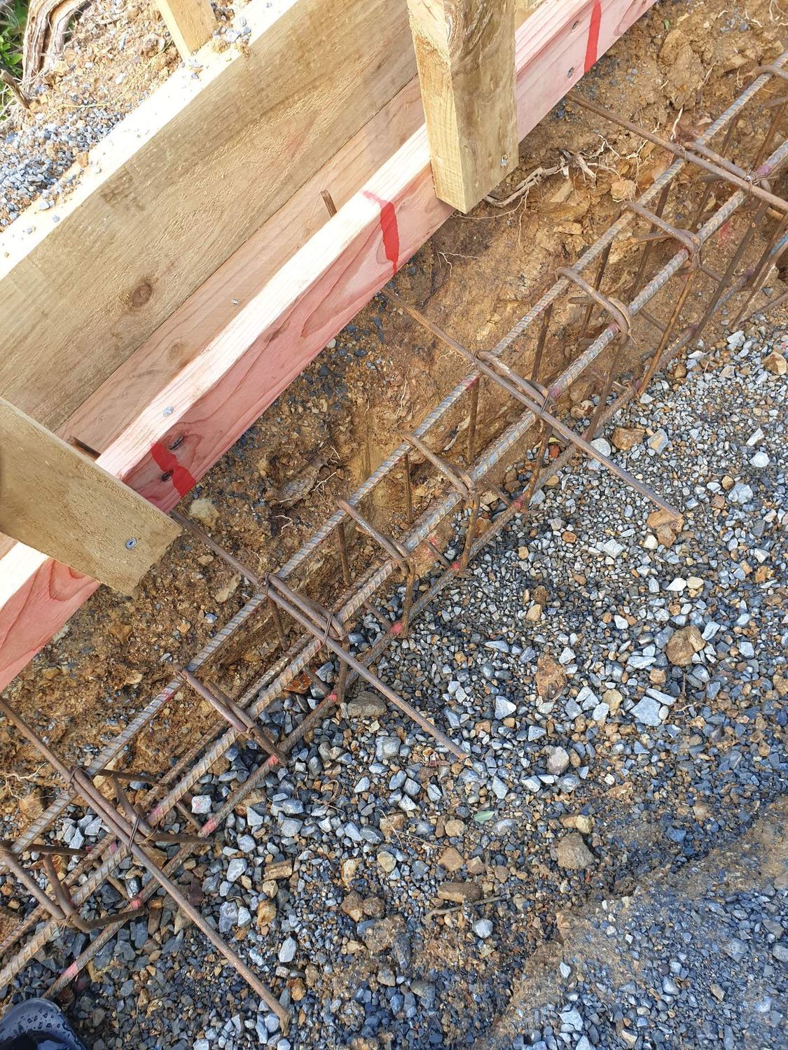 Reinforcing steel in a footing trench with timber boxing along one side